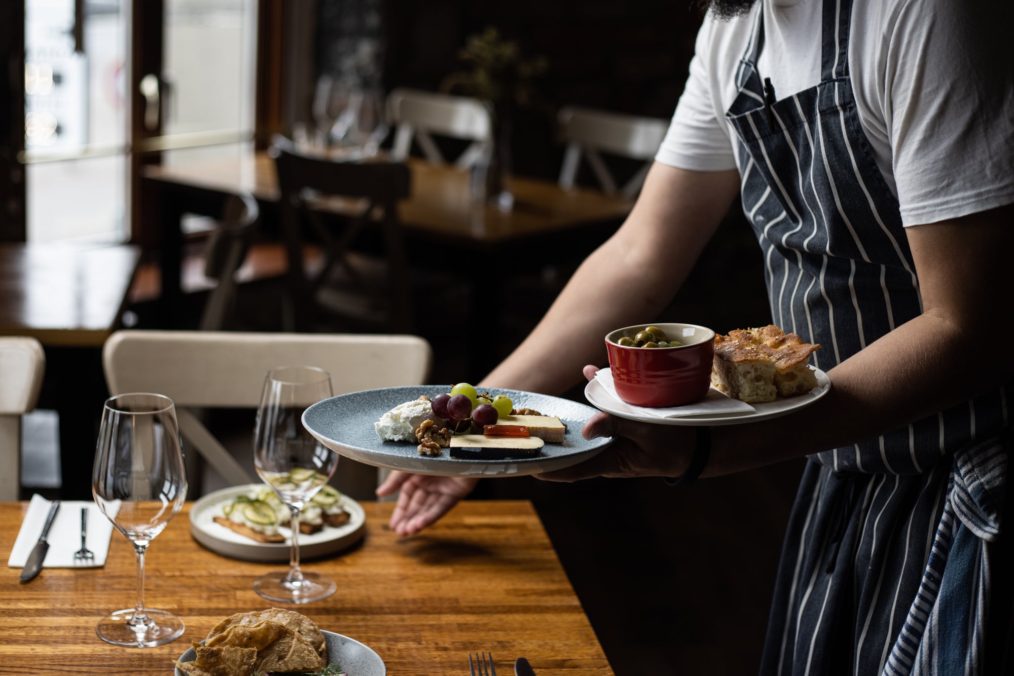 Chef leaves plates of food on a restaurant table